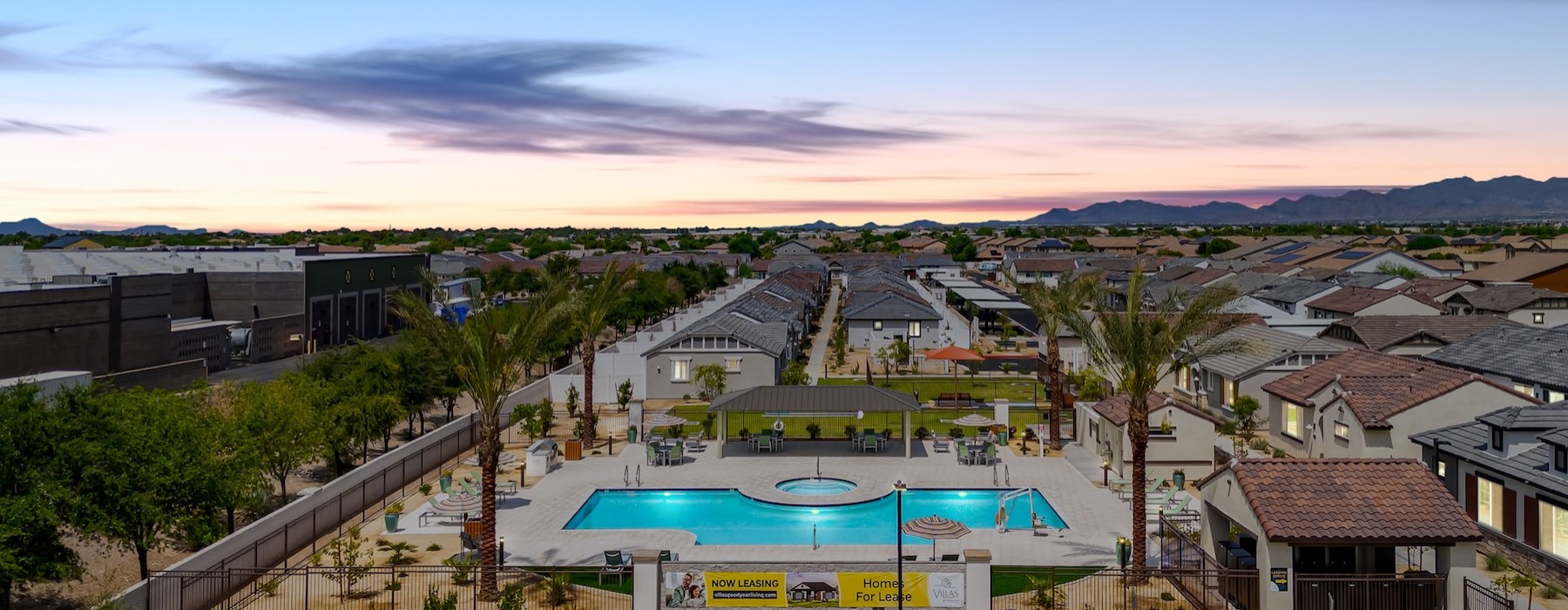 aerial view of a community with a large swimming pool and trees around