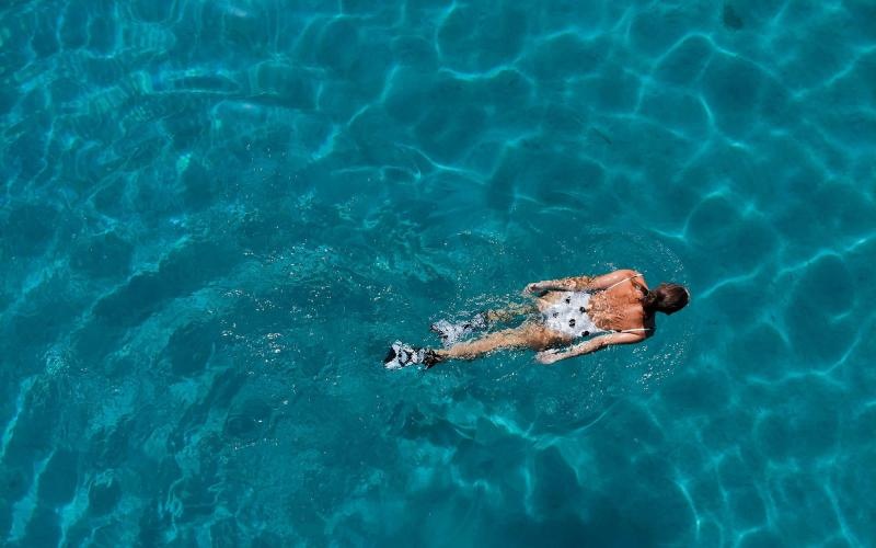 overhead shot of a woman swimming in a pool