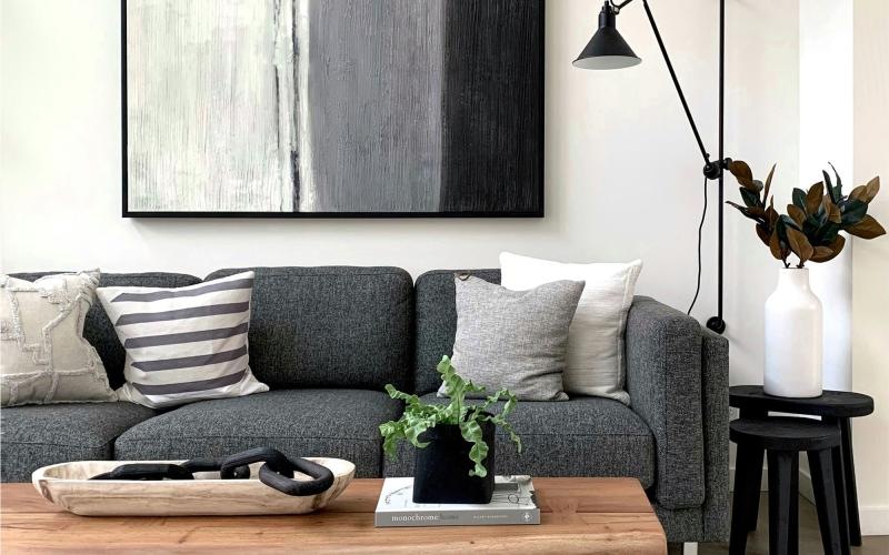 a couch with a coffee table with a plant and decor on it